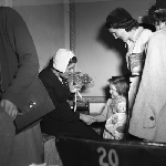 Cover image for Photograph - "Kindergarten of the Air", Miss Anne Dreyer receiving posy from a tiny admirer at demonstration at the Theatre Royal, Hobart
