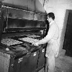 Cover image for Photograph - Haywoods Biscuit Factory, placing trays of Snax biscuits in oven