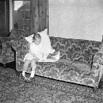 Cover image for Photograph - Small girl reads book on the couch