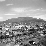 Cover image for Photograph - Goods train arriving at Hobart Railway Station, view to Mt. Wellington over Hobart