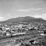Cover image for Photograph - Hobart Railway Station, passenger train leaving station, view to Mt. Wellington over Hobart