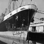 Cover image for Photograph - Hobart Wharf, "Theseus" apple boat, cleaning the hull