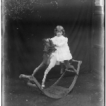 Cover image for Photograph - Mrs Dares daughter sitting on rocking horse