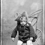 Cover image for Photograph - Studio portrait - young girl on chair wearing jacket