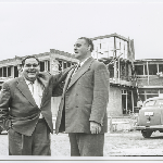 Cover image for Photograph - Chief Little Wolf & Francois Fouche , facing camera,  at Old Beach with hotel under construction at rear of photograph