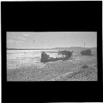 Cover image for Photograph - glass lantern slide - view of beach (Tasmanian?) with two boats - structure of front boat is decayed