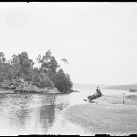 Cover image for Photograph - Glass negative - River [woman standing near dinghy]