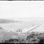 Cover image for Photograph - Glass negative - Farm [view from hillside overlooking wharf, across the bay to jetty and lookout tower, lighthouse?]
