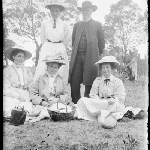 Cover image for Photograph - Glass negative - Parish picnic [Bush setting - Woman and man standing, three women sitting of ground with picnic basket and billy]