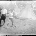 Cover image for Photograph - Glass negative - Parish picnic [two boys in bush setting playing game of quoits]