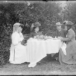 Cover image for Photograph - Glass negative - Farm [Three ladies and clergyman taking tea in a garden]