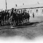 Cover image for Photograph - Soldiers in line  outside buildings with officer in front