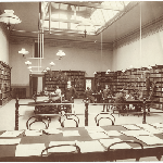 Cover image for The Reference Room of the new Carnegie Library. Librarian Alfred Taylor is standing centre.