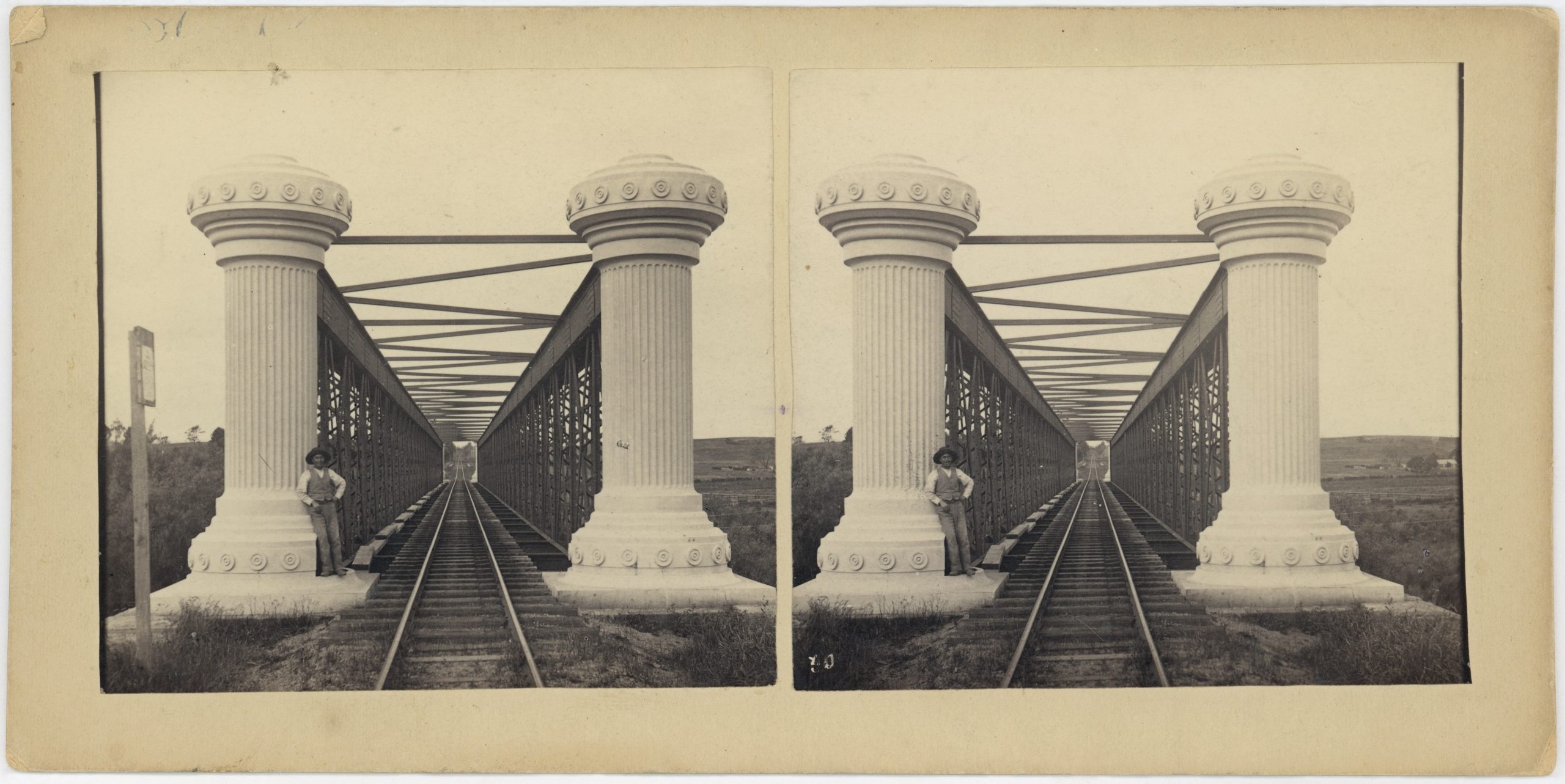 2 old black and white photos of the Longford railway bridge. a man stands beside one of the two white columns at the start of the bridge.