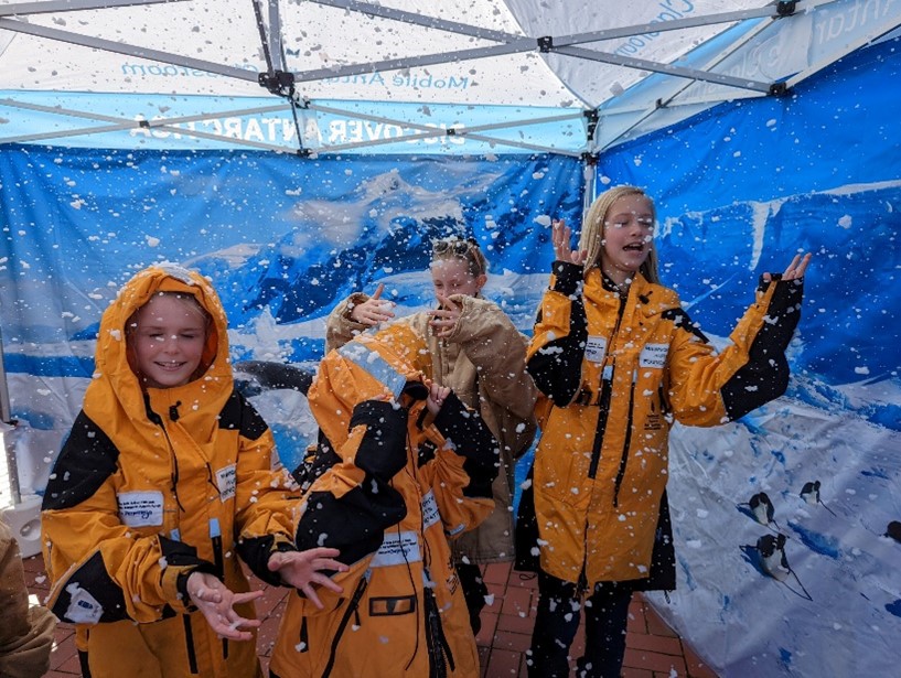 Children attending the mobile classroom play in the snow tent simulating the Antartica climate.