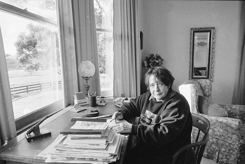 Image of Margaret Scott sitting at a desk with a pen and paper.