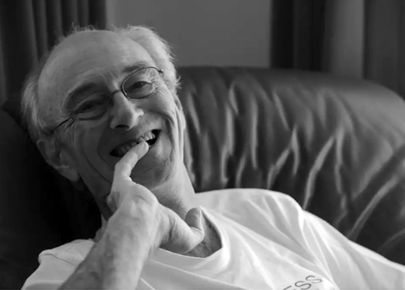 Image of Tim Thorne smiling at the camera while sitting on a couch.