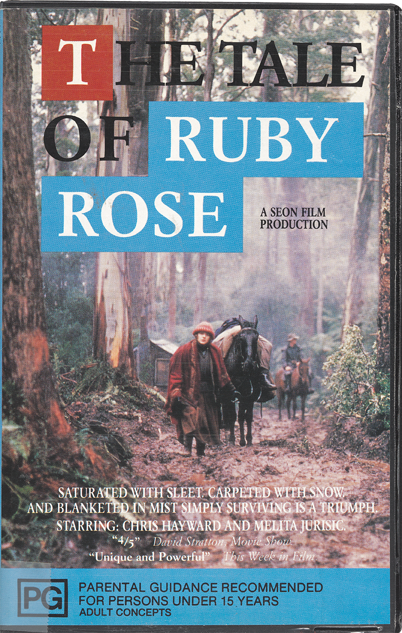 Cover of Roger Scholes’s The tale of Ruby Rose, VHS, 1987. Features a woman leading a horse through a muddy track in the forest. Rated PG for parental guidance.