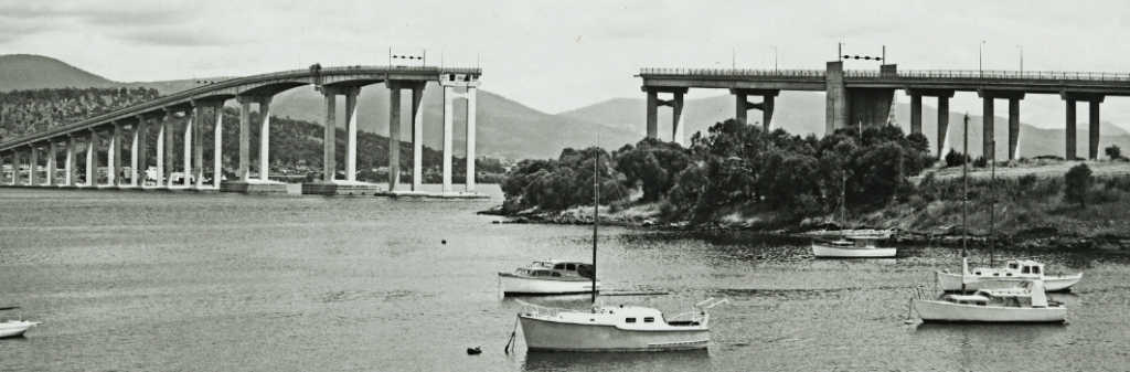 Black and white photograph showing the Tasman Bridge with missing spans