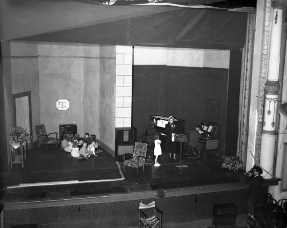 An old black and white photo of a kindergarten class on stage at the Theatre Royal