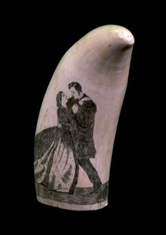 A whales tooth with a drawing of two people dancing on it.