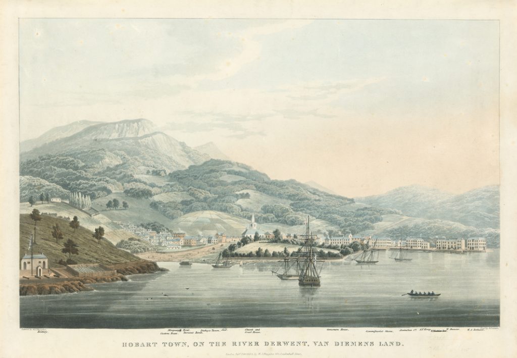 a river with boats, some buildings and mountains in the background