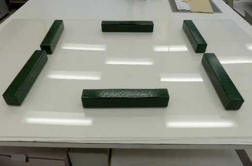 6 long blocks on top of a plastic sheet