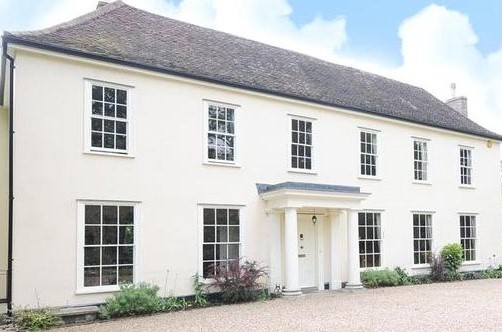 A photo of a 2 story, white hotel as seen from the front
