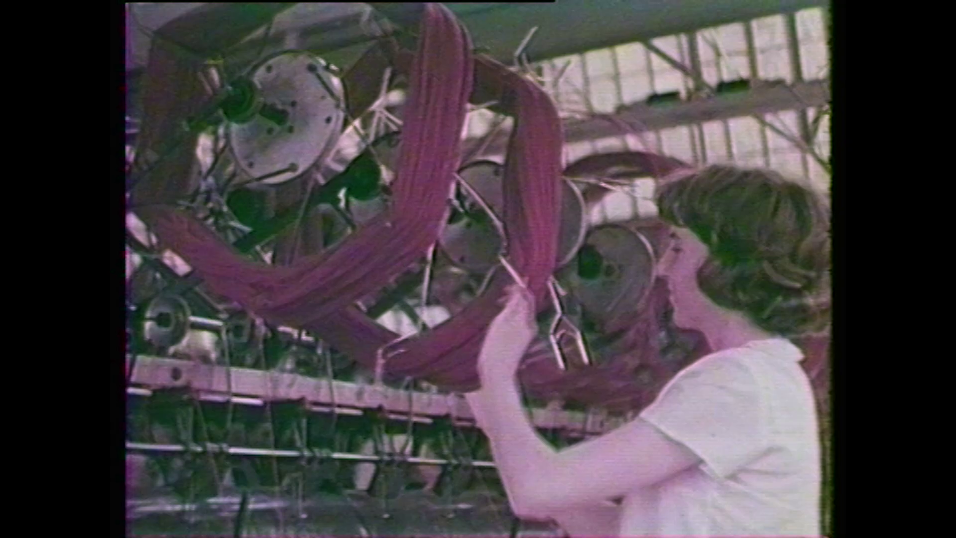 a still taken from Film – More Than Apples. A woman working with machinery.