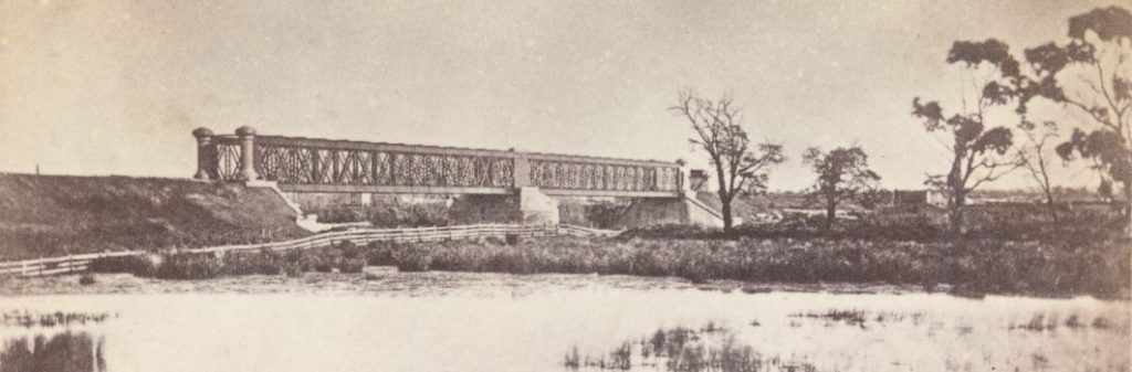 A black and white photo of a bridge.