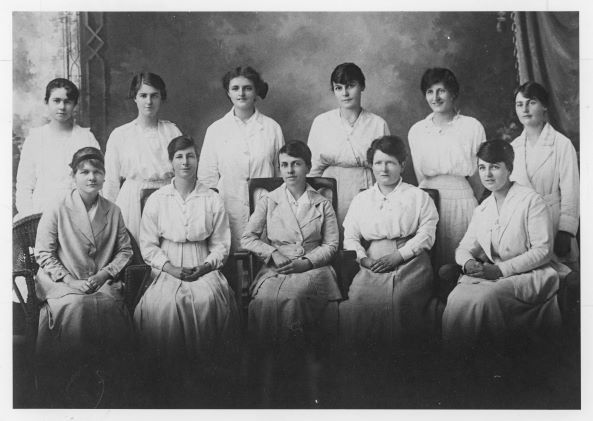 A black and white photo of 7 women posing for a photo