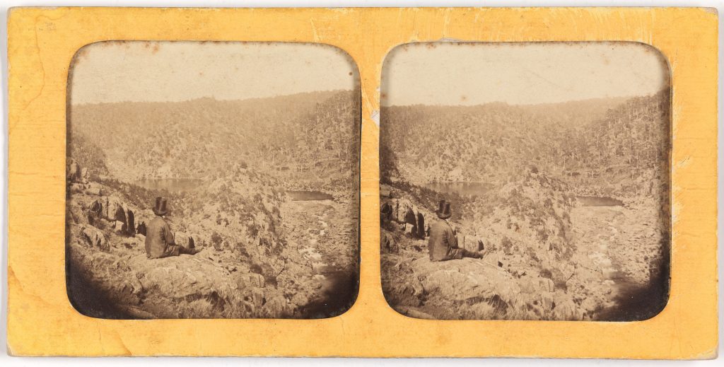 2 old black and white photo's. Both are the same. A man sites on the edge of a cliff overlooking a valley.