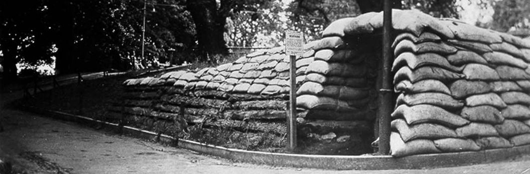 A structure made of sandbags on a street corner.