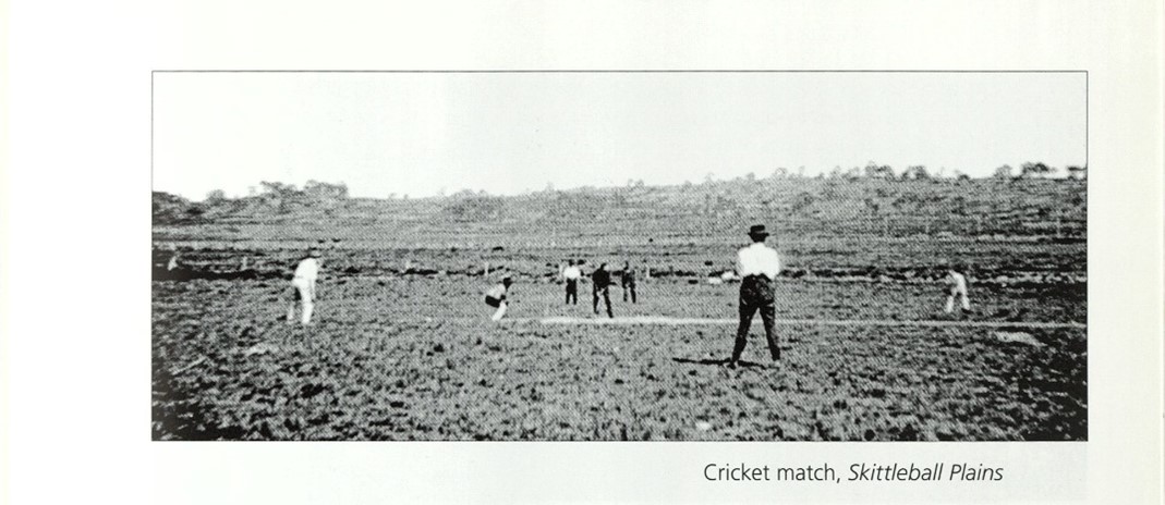An old photo of several people playing cricket