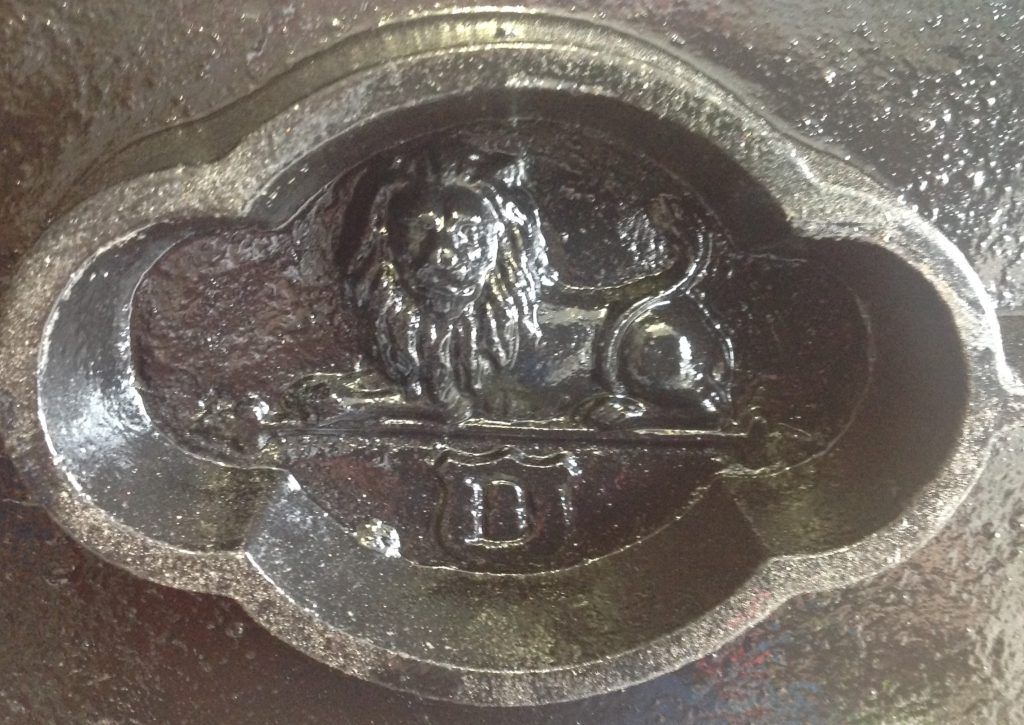 A photo of a markers mark on a copy press. the mark is of a lion and a letter D underneath.