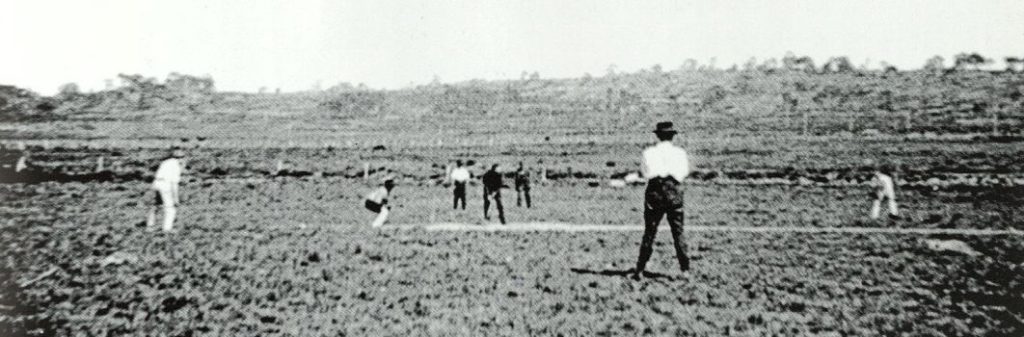 An old photo of several people playing cricket