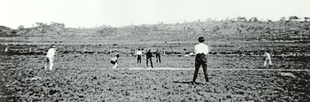 An old photo of several people playing cricket